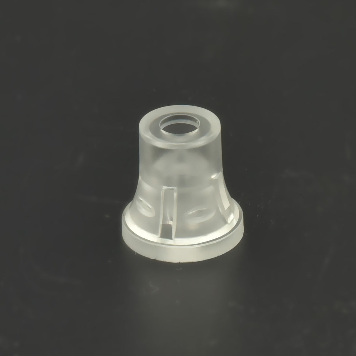 Distanțier cilindric transparent din plastic, privit de sus pe fundal negru.