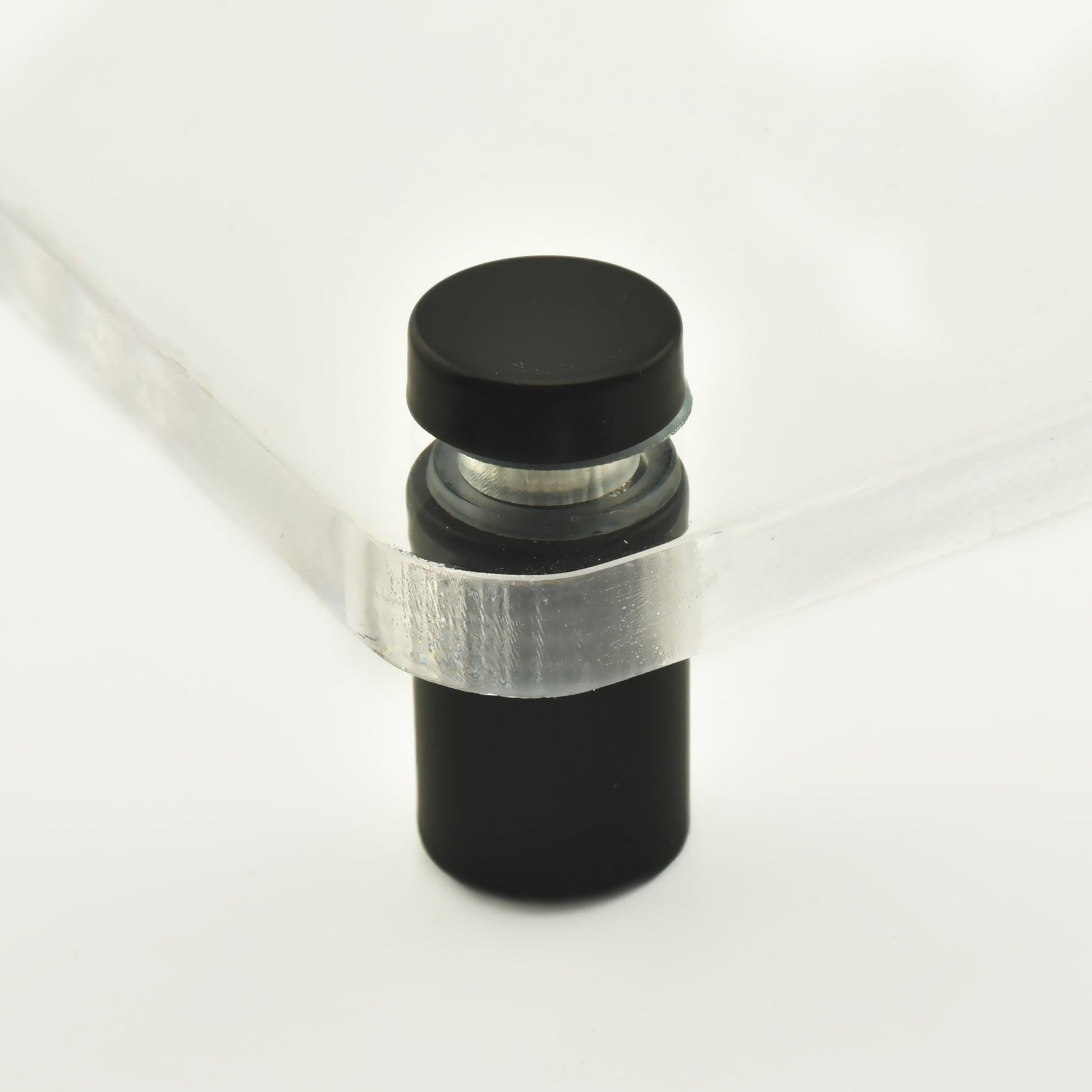 Distantier cilindric din inox de culoare gri inchis sau negru, asezat vertical.